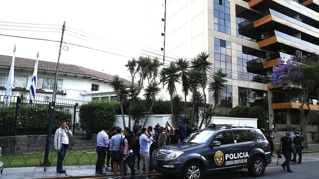 Poliiseja ja toimittajia Uruguayn suurlähetystön edessä Perussa. Maan entinen presidentti Alan Garcia haki suurlähetystöstä turvapaikkaa.