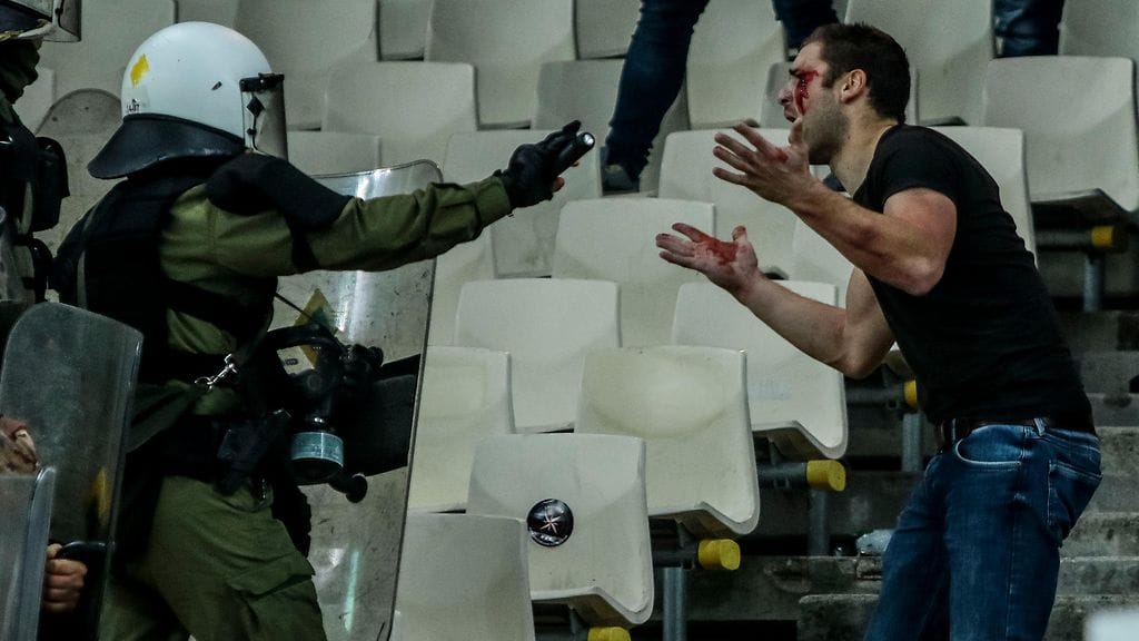 Mellakkapoliisi ja Ajaxin fani välienselvittelyssä.