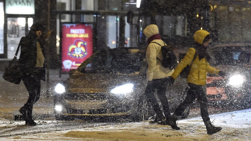 Jalankulkijoita ja autoja lumisateisena aamuna Helsingissä 17. joulukuuta 2018.