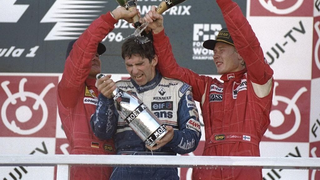 Mika Häkkinen ja Michael Schumacher uittavat Damon Hillia kuohuviinissä Suzukassa 1996.