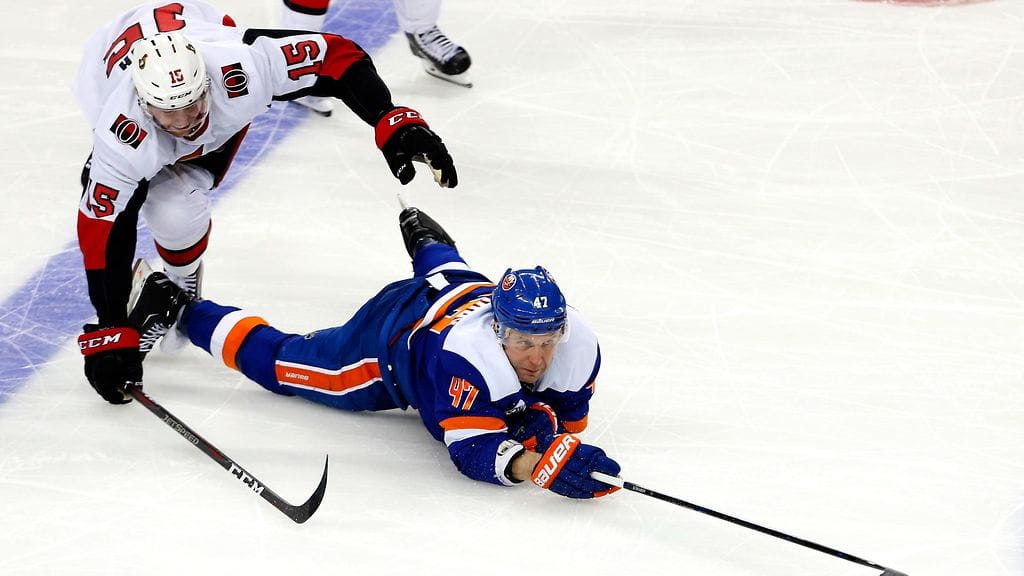 New York Islandersin Leo Komarov (jäässä) kamppailussa Ottawa Senatorsin Zack Smithiä vastaan.