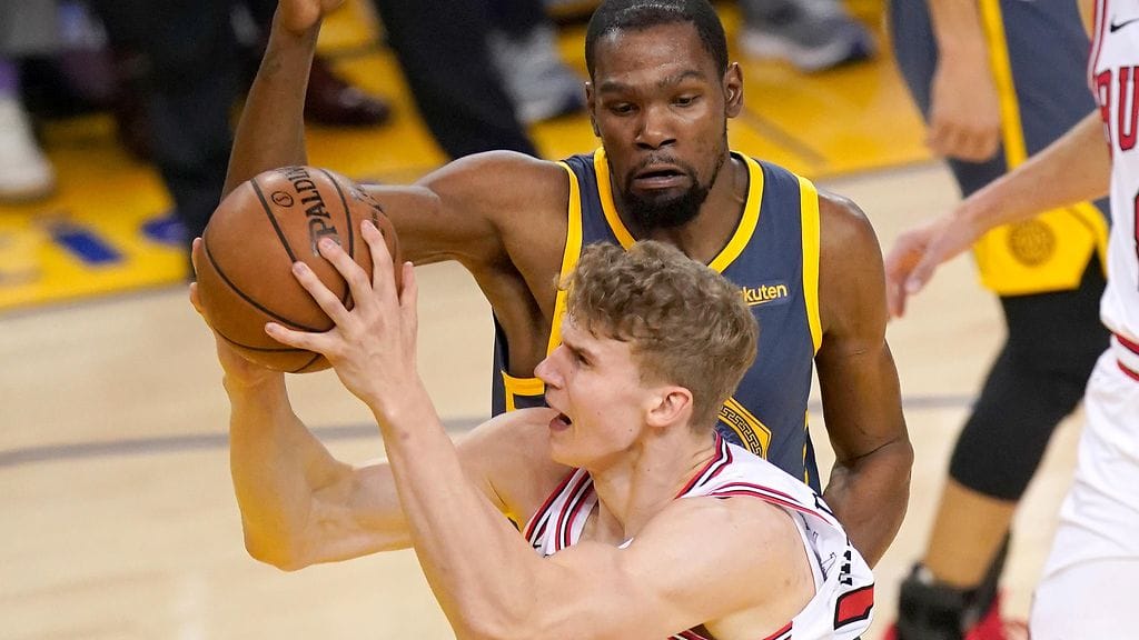 Chicago Bullsin Lauri Markkanen ajoi korille, kun Golden State Warriorsin Kevin Durant yritti pysäyttää suomalaisen.