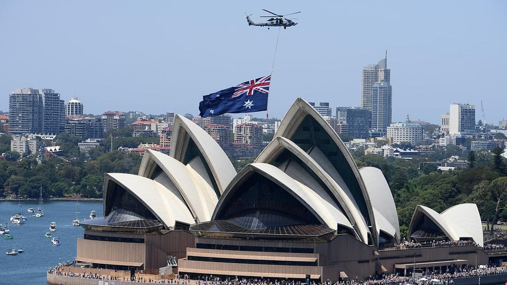 Australian kuninkaallisen laivaston helikopteri lentää Sydneyn oopperatalon yllä juhlallisuuksien kunniaksi.