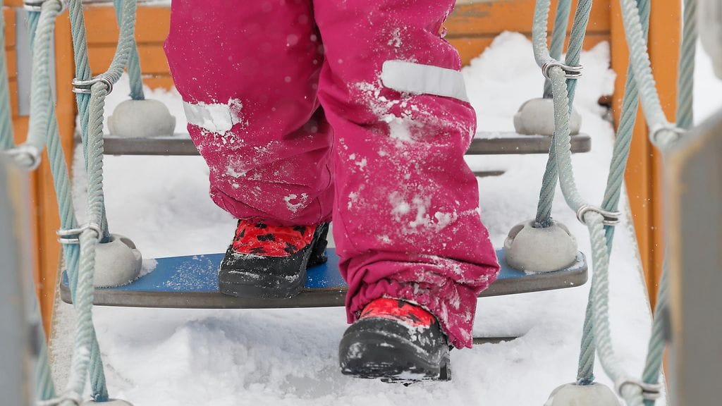 Kuvituskuvassa lapsi leikkimässä telineillä.