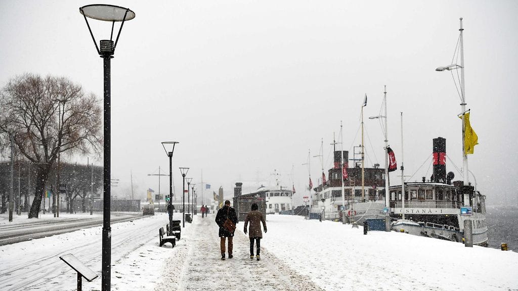 Kuvituskuvassa ihmisiä kävelemässä lumisateessa Tukholmassa eilen perjantaina.