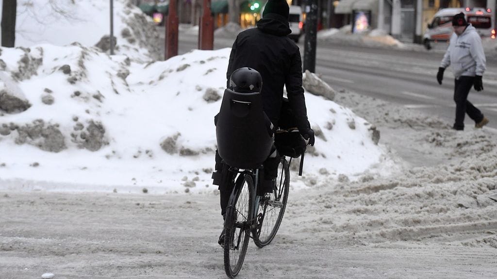 Pyöräilijä taituroi liukkaalla tiellä helmikuisessa Helsingissä.