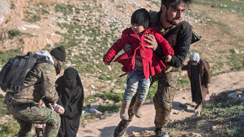 Kuvituskuvassa lapsia ja vanhuksia pakenemassa taiteluja Syyriassa.