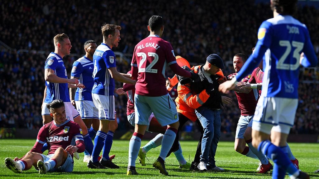 Aston Villan ja Birmingham Cityn ottelussa nähtiin fanin tekemä brutaali hyökkäys, jossa kentälle hyökännyt henkilö löi nyrkillä Aston Villan kapteenia Jack Grealishia (vasemmalla maassa).