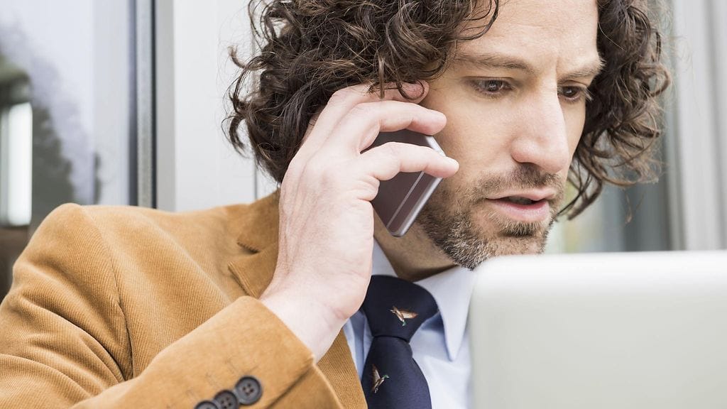 Mies puhuu puhelimeen. Kuvituskuva.