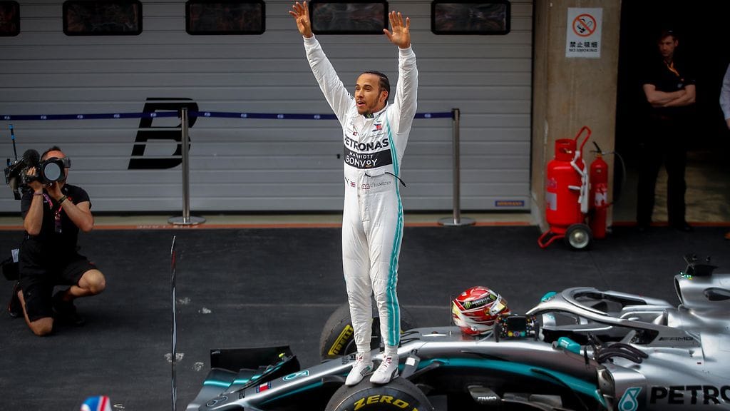 Lewis Hamilton nosti kätensä pystyyn juhliessaan Kiinan GP:n voittoa.