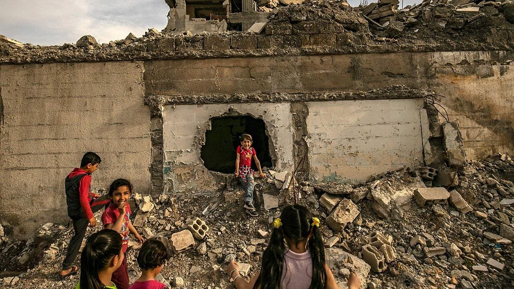 Lapsia leikkimässä raunioilla Raqqassa.