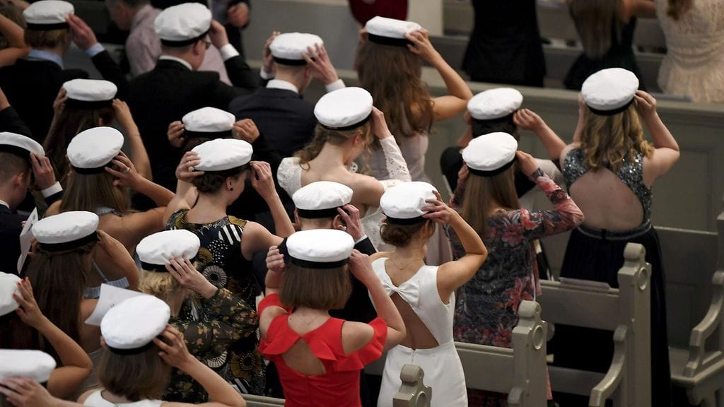 Kuvituskuvassa uudet ylioppilaat laittavat ylioppilaslakit päähän Ressun lukion ylioppilasjuhlissa Helsingin Vanhassa Kirkossa 2. kesäkuuta 2018.