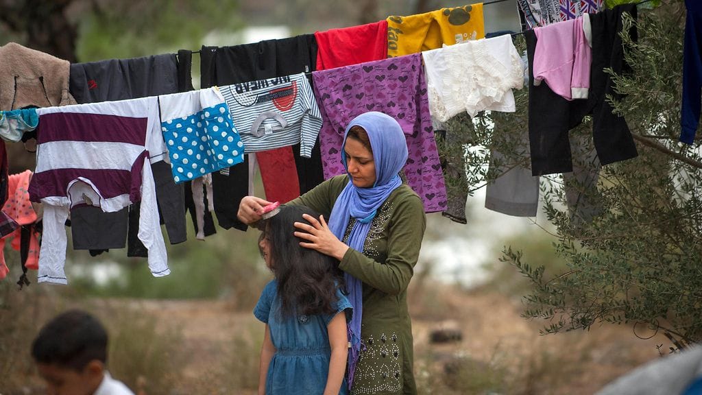 Äiti kampasi tyttärensä hiuksia pakolaisleirillä Lesboksen saarella, Kreikassa vuonna 2015.