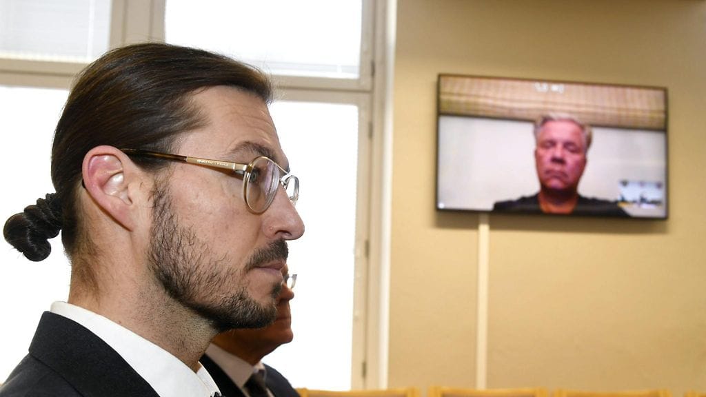 Vastaajat Iisakki Kiemunki (etualalla) ja Markku Ritaluoma (videoyhteyden kautta) autokauppa Sunny Car Centerin konkurssiin liittyvien vahingonkorvauksien käsittelyistunnossa Kanta-Hämeen käräjäoikeudessa Hämeenlinnassa 1. maaliskuuta 2018.