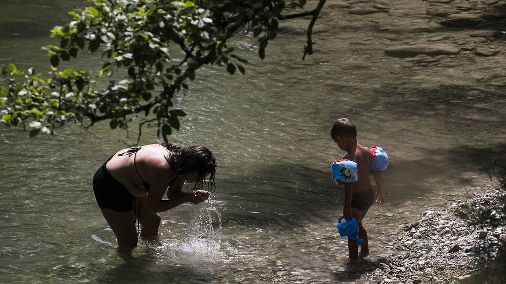 Ihmiset viilensivät itseään joessa Saint Jean-d Arveyssa, Ranskassa. Ranskassa lämpötilan pelätään kohoavan yli 40 asteeseen.