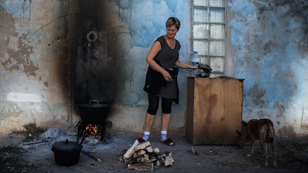 Nainen valmisti ruokaa ulkotulella, kun Avdeevkan kaupungin sähkön- ja vedenjakelu keskeytyi taistelujen vuoksi vuonna 2014.