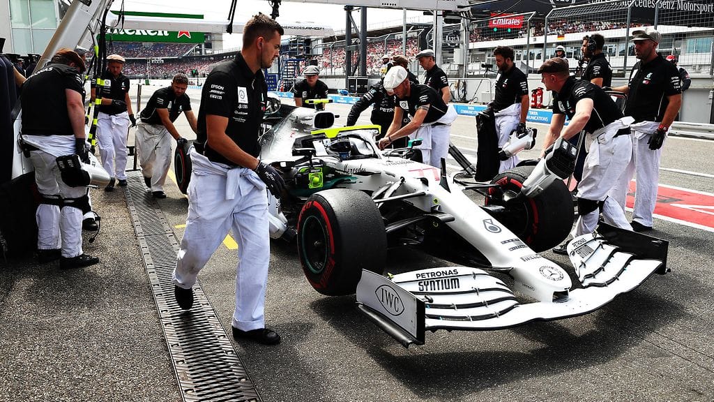 Retroasuihin pukeutuneet Mercedes-mekaanikot valmistivat Valtteri Bottaksen autoa radalle harjoituksissa.