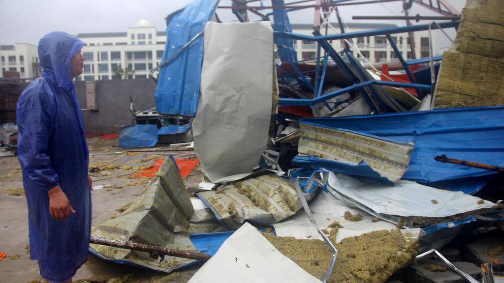 Mies etsii omaisuuttaan Kiinan Zhejiangin provinssissa taifuuni Lekiman aiheuttamien tuhojen jäljiltä.