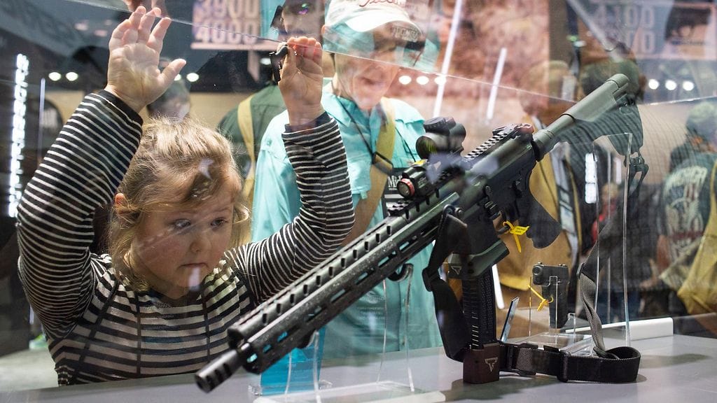 Nuori tyttö katseli John Wick -elokuvaan tulossa olevaa asetta asejärjestö NRA:n tapahtumassa vuonna 2012.