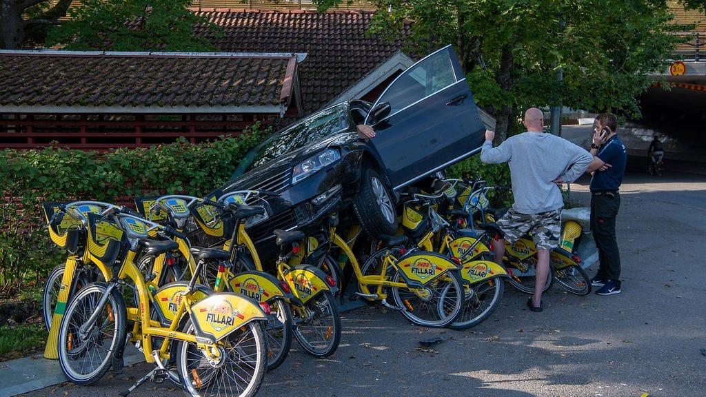 Henkilöauto oli pahasti kyljellään sen ajettua polkupyöräparkin yli. Auton kuljettajalla oli hankaluuksia päästä ulos ajoneuvosta.