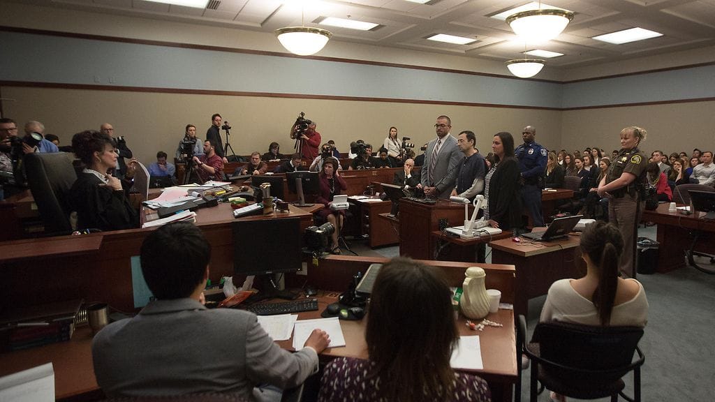Larry Nassar (kuvassa oikealla siniharmaissa vankilavaatteissa) kuulemassa tuomionsa oikeudenkäynnissä vuonna 2018. Hänet tuomittiin yli 150 naisen ja tytön hyväksikäytöstä.