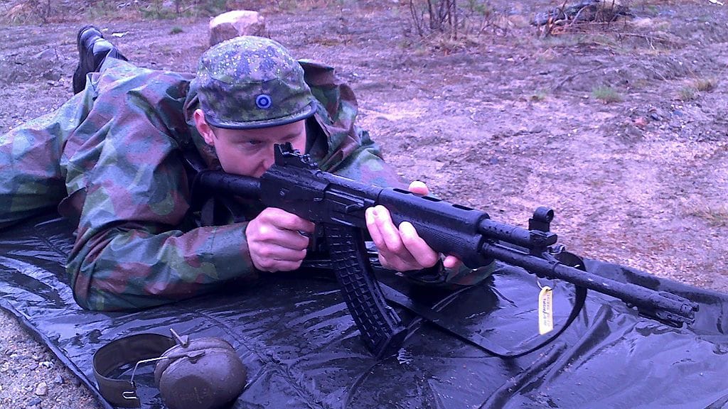 Mikko Koivu ja rynnäkkökivääri.