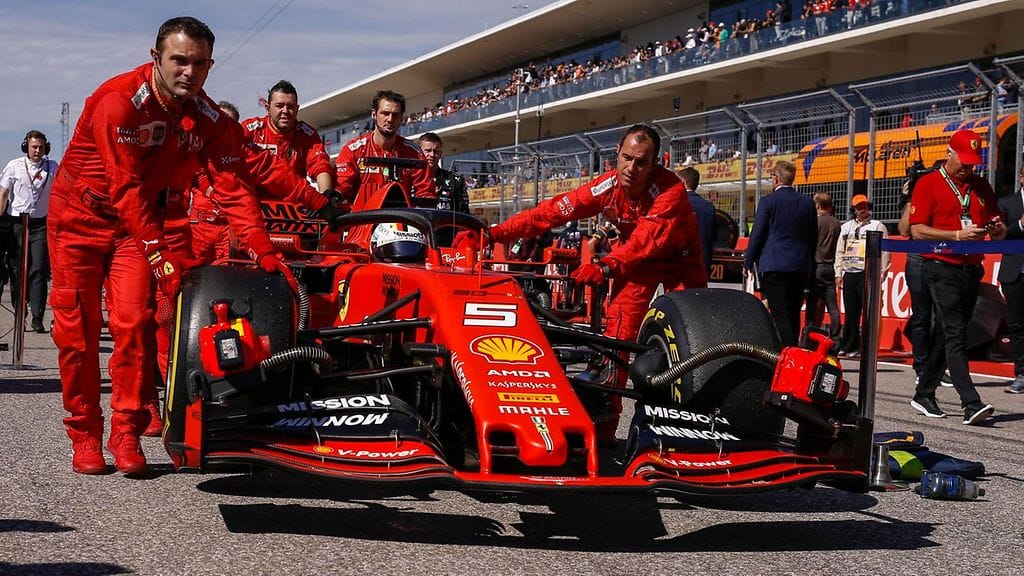 Ferrarin mekaanikot tuovat Sebastian Vettelin autoa lähtöruudukkoon Austinissa.