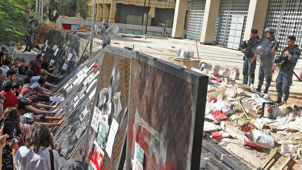 Hallitusta vastustavat mielenosoittajat kaatoivat Libanonin keskuspankin  ympärille pystytettyä aitaa Beirutissa maanantaina.