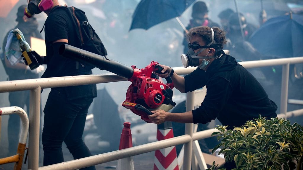 Mielenosoittaja puhalsi lehtipuhaltimella poliisin ampumaa kyynelkaasua viime viikolla Hongkongin Teknillisellä yliopistolla.