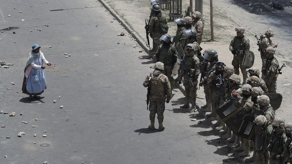 Mielenosoittajiin kuulunut nainen lähestyi poliiseja heidän hajoitettuaan väliaikaista presidentti Anezia vastustaneen mielenosoituksen El Alton kaupungissa tiistaina.