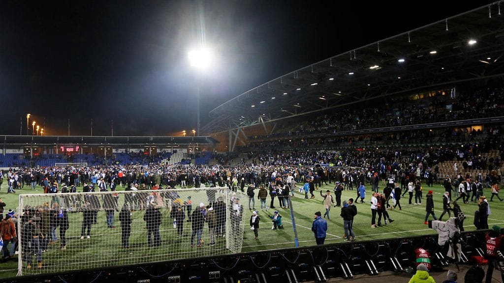 Fanit täyttivät Töölön jalkapallostadionin nurmen Liechtenstein-voiton jälkeen.