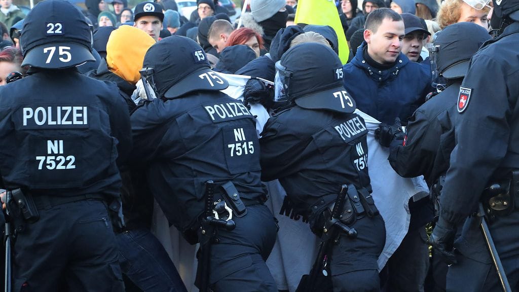 Mielenosoittajat ja poliisit Pohjois-Saksassa.