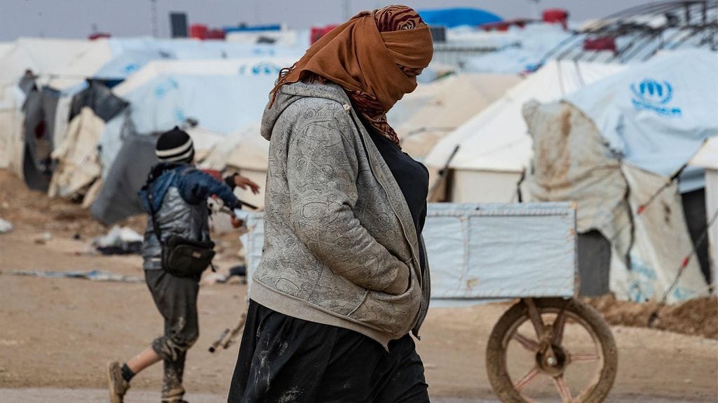 Nainen kulki Al-holin leirillä joulukuussa. Hallitus ja oppositio on ajautunut kiistaan leirillä olevista suomalaisista.