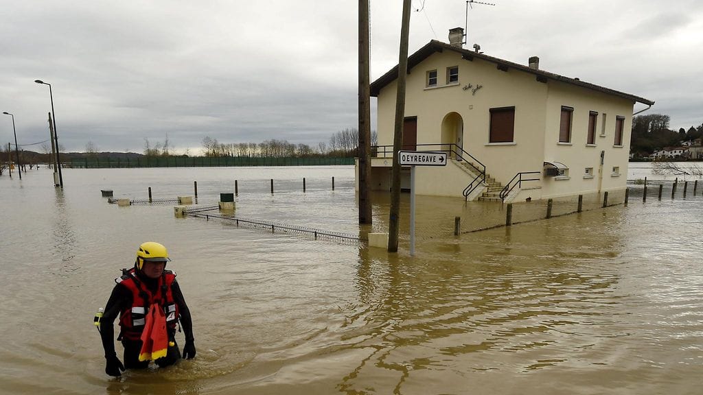Pelastaja kahlasi tulvan keskellä Peyrehoradessa, Lounais-Ranskassa lauantaina.