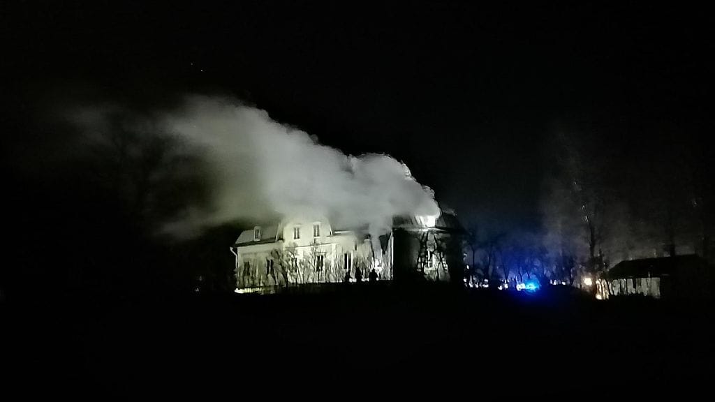 Maatilarakennus savusi Salossa pimeyden keskellä.
