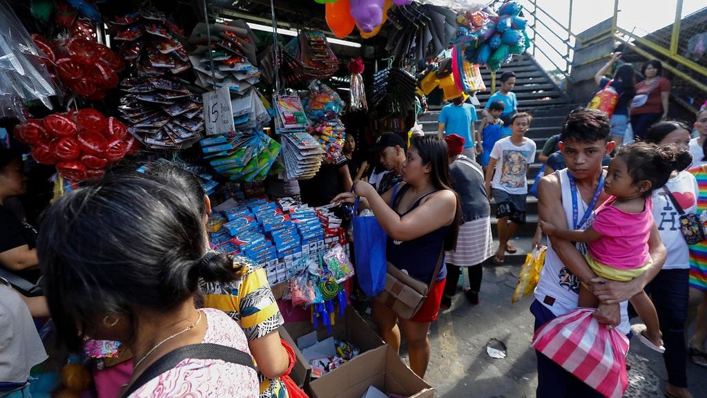 Ihmisiä parveili torilla ostoksilla jouluaattona Quezonin kaupungissa.