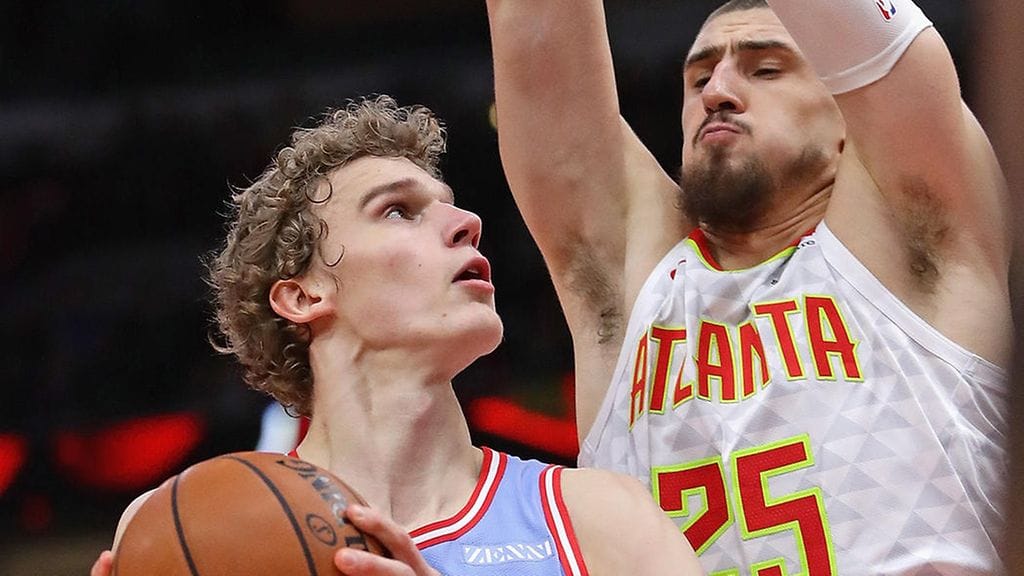 Lauri Markkanen taistelussa Hawksin Alex Lenin kanssa korin alla.