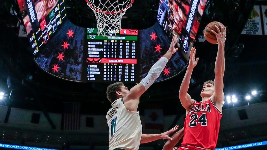 Lauri Markkanen ujuttaa palloa koriin yli Brook Lopezin.