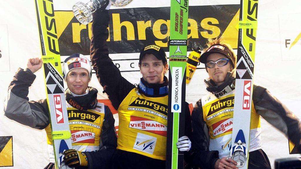 Janne Ahonen juhli vuonna 2004 maailmancupin kokonaisvoittoa, palkintopallilla Norjan Roar Lakelsoy (vas.) ja Bjørn Einar Romøren.