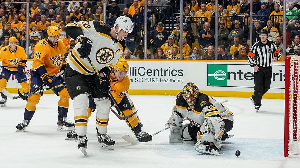 Nashvillen Mikael Granlund ahnehtimassa kiekon perään Tuukka Raskin vartioimalla Boston-maalilla.