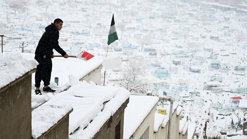 Arkistokuva. Mies loi lunta talonsa katolla Kabulissa 2. tammikuuta 2020.