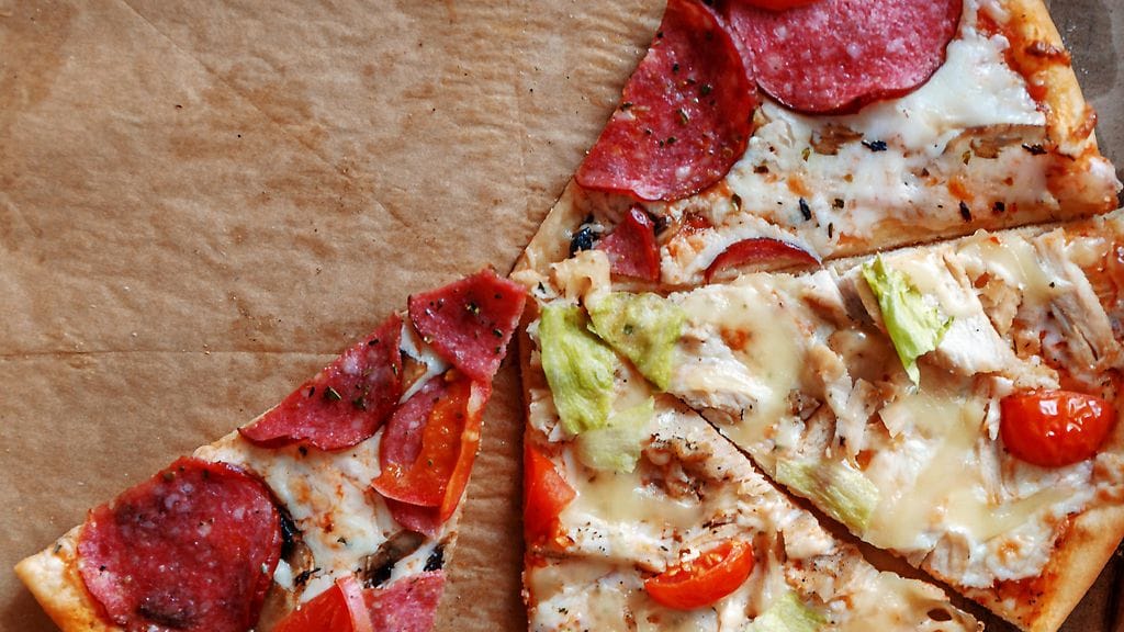 Pizzaa leivinpaperin päällä. Kuvituskuva.