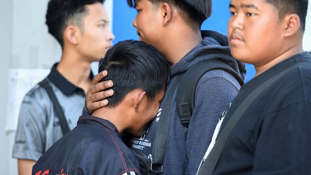 Nuoren Atiwat Promosookin ystävät surivat kauppakeskuksen ulkopuolella, kun hänen kerrottiin menehtyneen ammuskelussa.