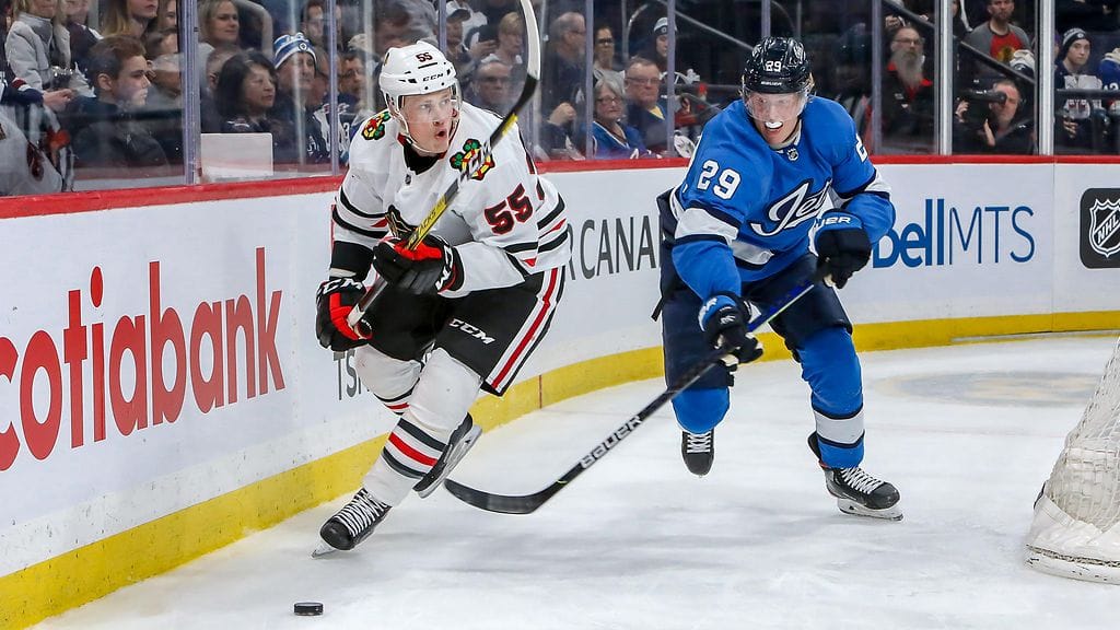 Patrik Laine jahtaamassa kiekkoa Chicago Blackhawksin Nick Seelerin perässä.