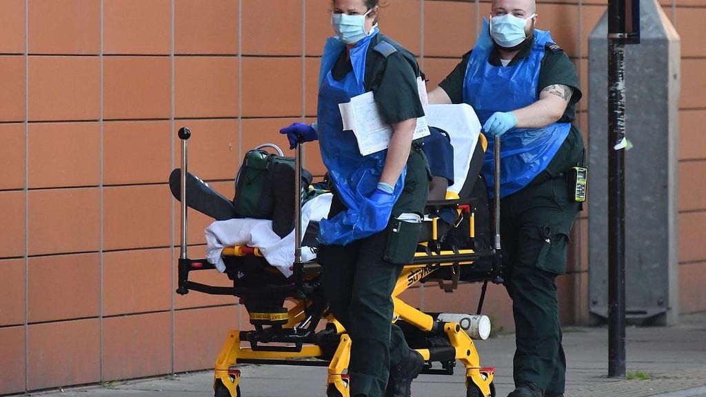 Ensihoitajat veivät koronapotilasta sairaalaan Lontoossa tiistaina.