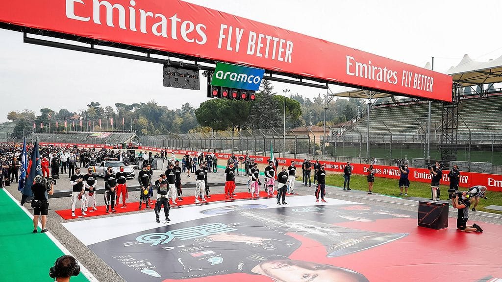 Tähän kuvaan tiivistyy F1:n tuoreeseen kisaisäntään liittyvä ristiriita: kuljettajat ottavat kantaa yhdenvertaisuuden puolesta, ja heidän yläpuolellaan paistaa ihmisoikeusloukkauksista tunnetun Saudi-Arabian kansallisen kaasu- ja öljy-yhtiön Aramcon logo.