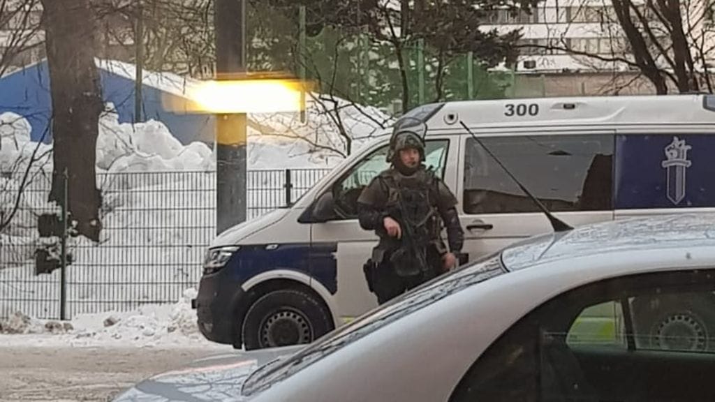 Helsingissä Brahen kentän läheisyydessä otetussa kuvassa näkyy raskaasti aseistautunut poliisi.