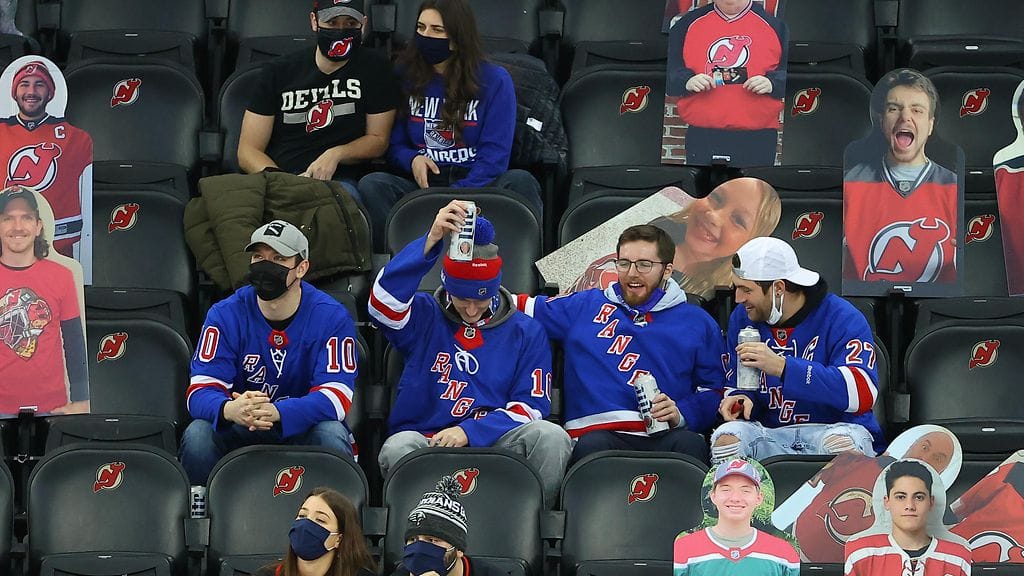 New Jersey Devils piruili New York Rangers -fanin kanssa heilastelevalle kannattajalleen.