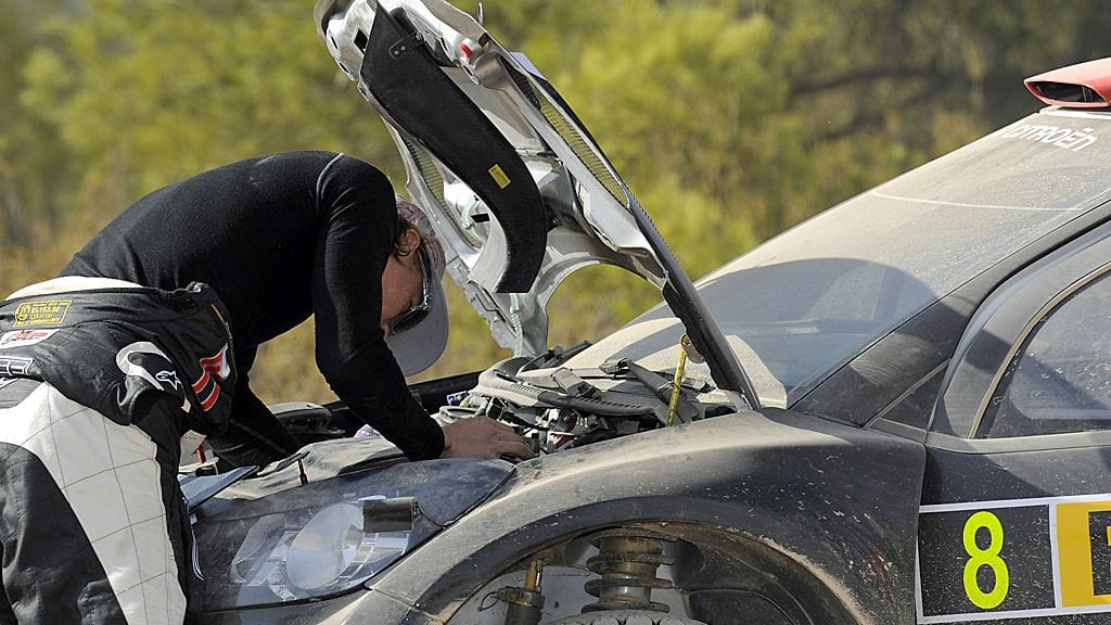 Kimi Räikkönen tutkimassa autonsa moottoritilaa.