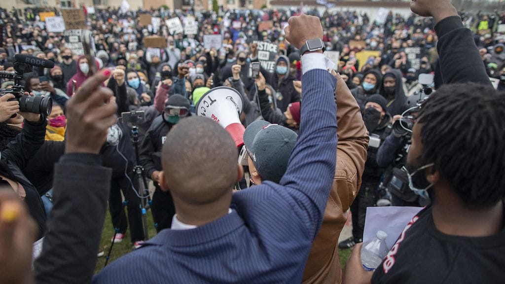 Mielenosoittajat nostivat nyrkkinsä ilmaan 13. huhtikuuta Brooklyn Centerin poliisiaseman edustalla, jossa mustan Daunte Wrightin ampunut poliisi työskenteli.